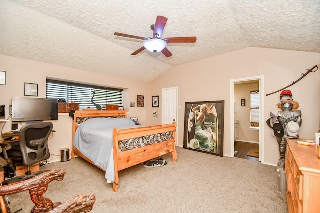 bedroom with ensuite bath, vaulted ceiling, a textured ceiling, and ceiling fan