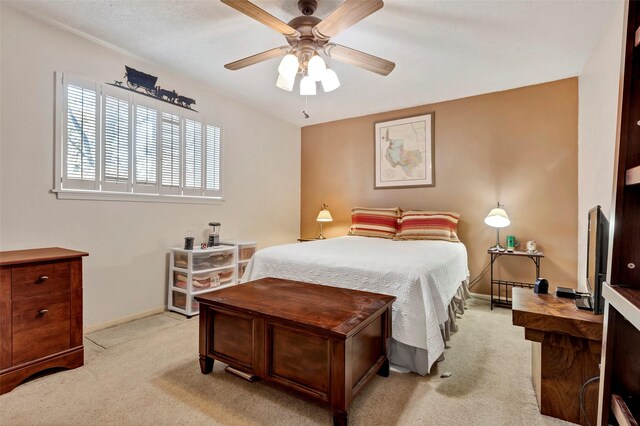 bedroom with ceiling fan and light carpet