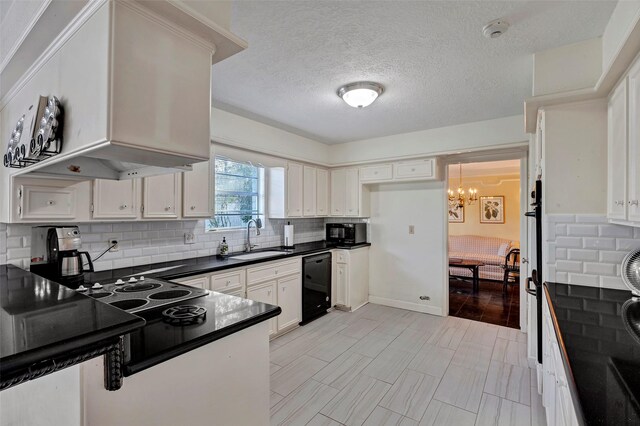 kitchen with sink, white cabinets, an inviting chandelier, and black appliances