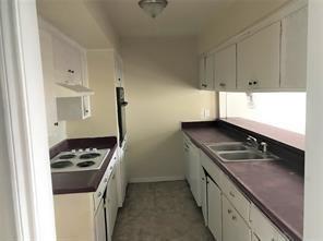 kitchen with wall oven, sink, white cabinets, and white stovetop