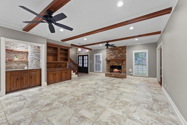 unfurnished living room with beamed ceiling, baseboards, a brick fireplace, and crown molding