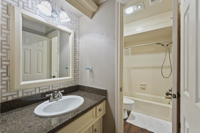 bathroom with visible vents, toilet, vanity, and shower / tub combo