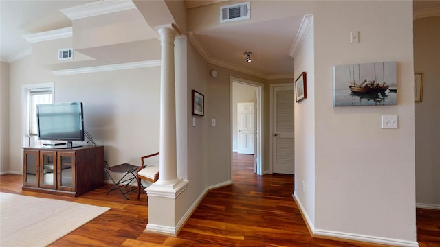 corridor featuring dark hardwood / wood-style flooring, decorative columns, and ornamental molding