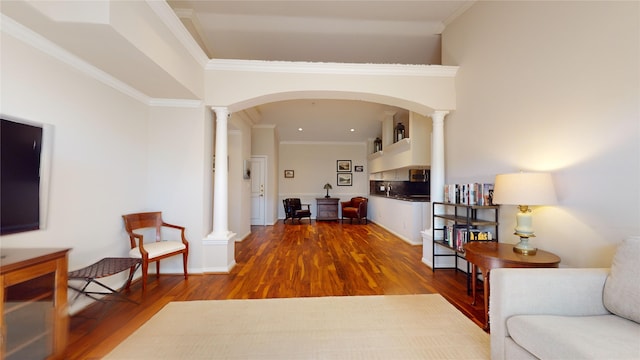 hallway featuring hardwood / wood-style floors, ornamental molding, and ornate columns