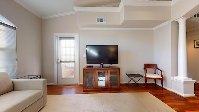 living room with hardwood / wood-style flooring, ornate columns, and crown molding