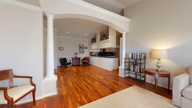 interior space featuring wood-type flooring, decorative columns, and ornamental molding