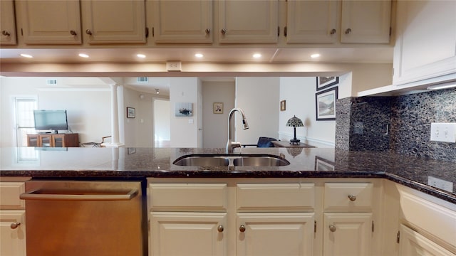 kitchen featuring dishwasher, dark stone counters, sink, tasteful backsplash, and kitchen peninsula