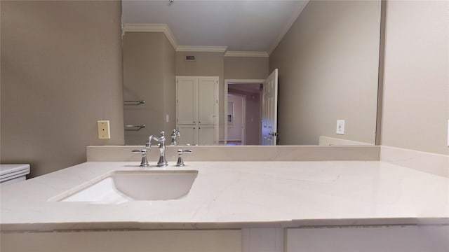 bathroom featuring vanity, toilet, and ornamental molding