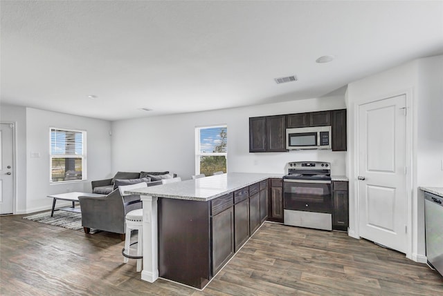 kitchen with a wealth of natural light, a breakfast bar area, stainless steel appliances, and kitchen peninsula