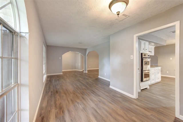 spare room with a textured ceiling and wood-type flooring