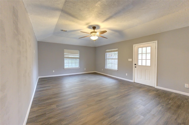 unfurnished room featuring dark wood-type flooring, ceiling fan, plenty of natural light, and a textured ceiling