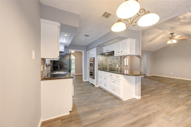 kitchen with white cabinets, lofted ceiling with beams, decorative backsplash, and sink