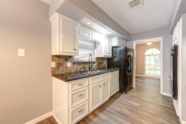 kitchen featuring tasteful backsplash, white cabinets, dishwasher, and sink