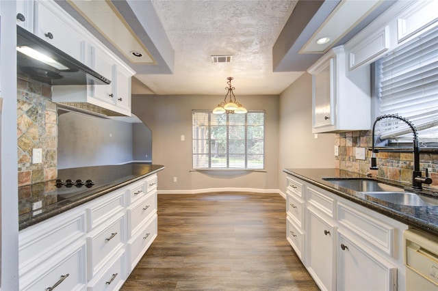 kitchen featuring hanging light fixtures, sink, white dishwasher, and white cabinetry