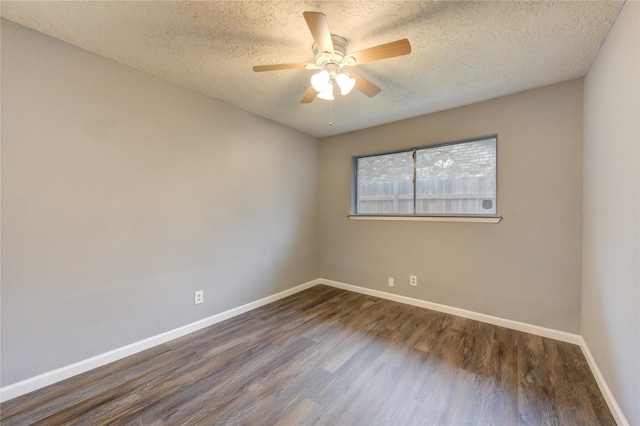 empty room featuring ceiling fan, dark wood-type flooring, and a textured ceiling