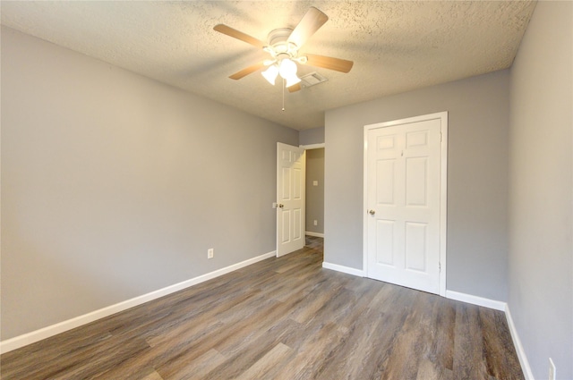 unfurnished bedroom with ceiling fan, dark wood-type flooring, and a textured ceiling