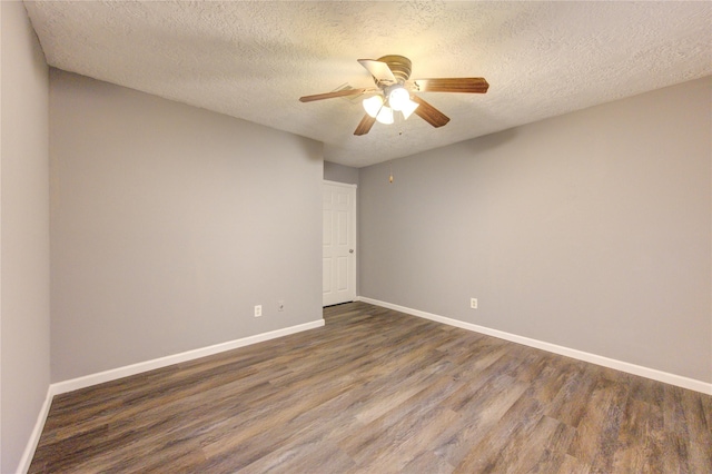 empty room featuring ceiling fan, dark wood-type flooring, and a textured ceiling