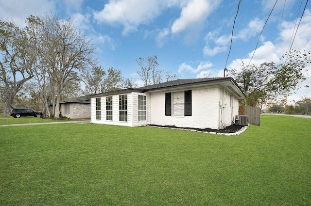 view of front of property with a front lawn and central AC unit