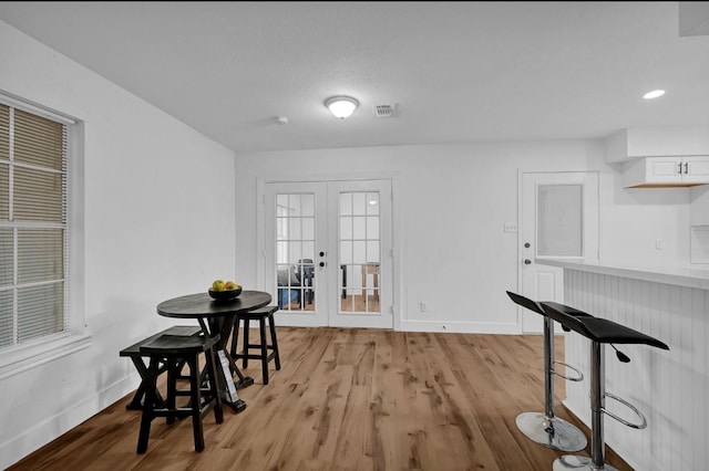 dining room with light hardwood / wood-style flooring and french doors