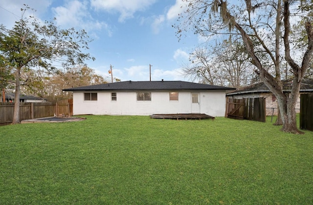 rear view of house featuring a yard and a wooden deck