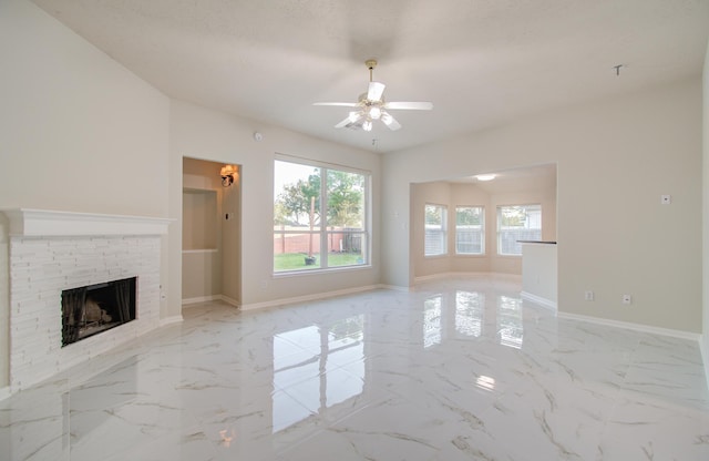 unfurnished living room with a textured ceiling, ceiling fan, and a fireplace