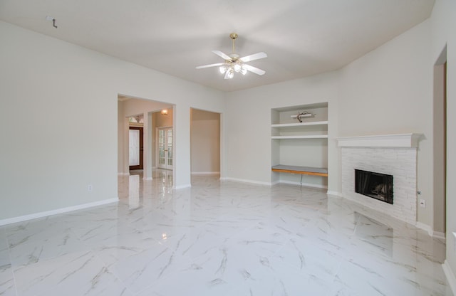 unfurnished living room with a stone fireplace and ceiling fan