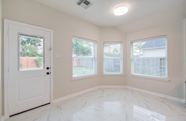 doorway to outside with a textured ceiling and vaulted ceiling