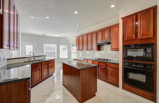 kitchen featuring black appliances, sink, decorative backsplash, a textured ceiling, and a kitchen island