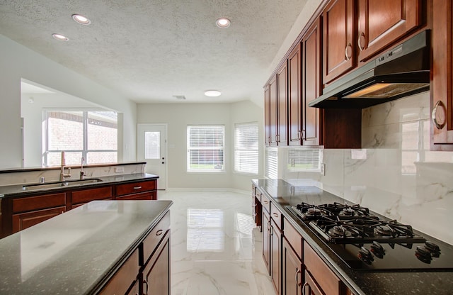 kitchen featuring backsplash, black gas stovetop, sink, and a textured ceiling