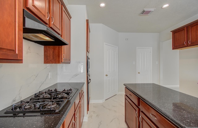 kitchen featuring decorative backsplash, black gas stovetop, and dark stone countertops