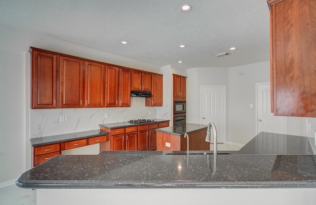 kitchen featuring black appliances, a kitchen island, backsplash, and dark stone counters