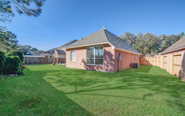 back of house featuring a lawn and cooling unit