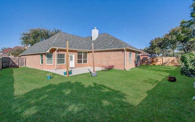 back of house with a yard and a patio