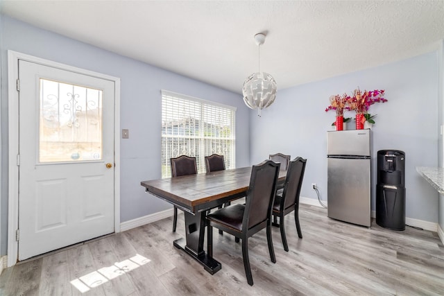 dining room with light wood-type flooring and a chandelier