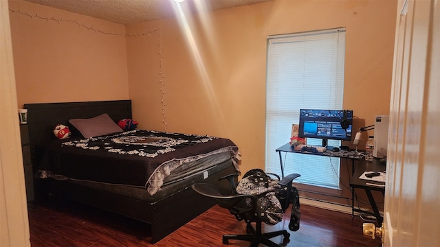 bedroom featuring dark wood-type flooring and a textured ceiling