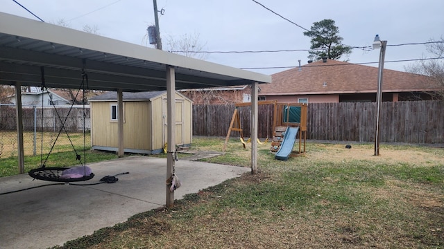 view of yard with a playground, a patio area, and a shed