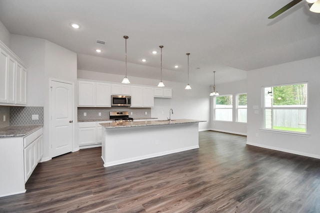 kitchen featuring white cabinetry, dark hardwood / wood-style floors, pendant lighting, a kitchen island with sink, and appliances with stainless steel finishes