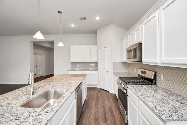 kitchen featuring decorative backsplash, white cabinetry, sink, and appliances with stainless steel finishes