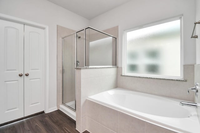 bathroom with hardwood / wood-style flooring and separate shower and tub