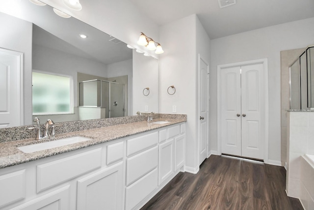 bathroom with vanity, wood-type flooring, and a shower with shower door