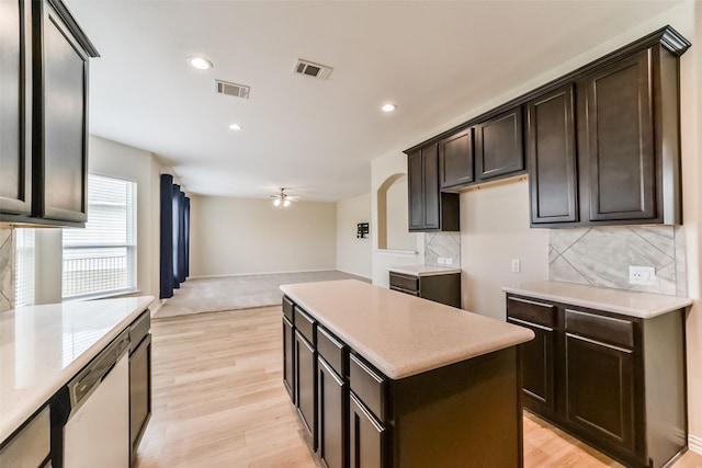 kitchen with decorative backsplash, ceiling fan, dishwasher, a center island, and light hardwood / wood-style floors