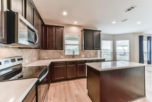 kitchen with a healthy amount of sunlight, sink, light hardwood / wood-style flooring, and appliances with stainless steel finishes