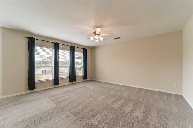 empty room featuring ceiling fan and light carpet