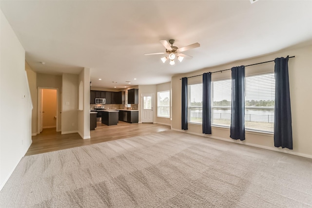 unfurnished living room with ceiling fan and light carpet