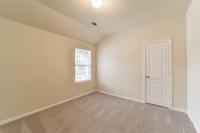 spare room with carpet flooring and lofted ceiling