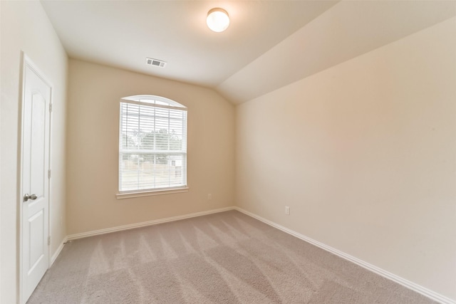 carpeted empty room with lofted ceiling