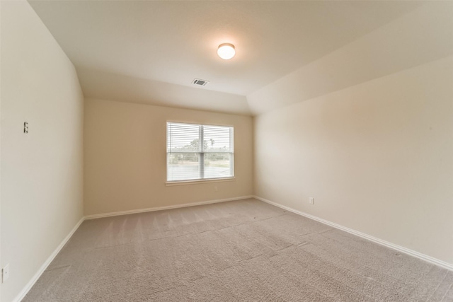 empty room featuring light carpet and lofted ceiling