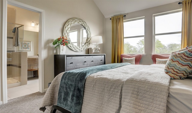 bedroom with light carpet, ensuite bath, and lofted ceiling