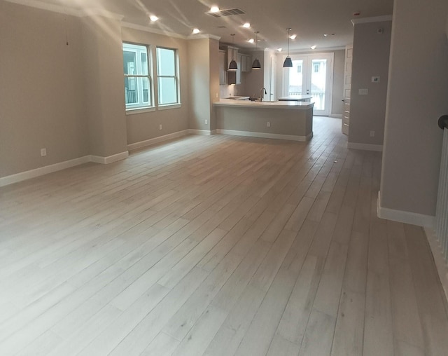 unfurnished living room featuring sink and light hardwood / wood-style flooring