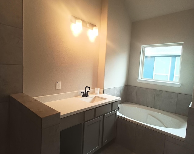 bathroom featuring vanity and a relaxing tiled tub